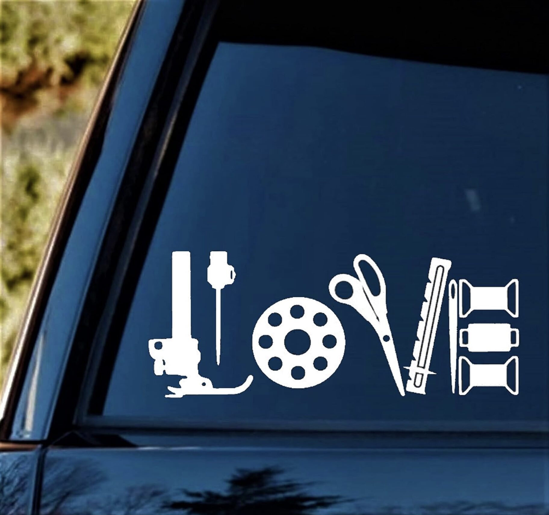 White kitchen utensil icons (whisk, rolling pin, ladle) arranged on a blue surface, like a decorative graphic on a window side panel.